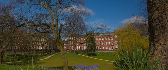 The lawn and mature trees of Winckley Square in Preston with the terrace behind