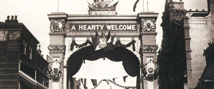 A decorated arch reading A Hearty Welcome erected across a Preston street for the Guild