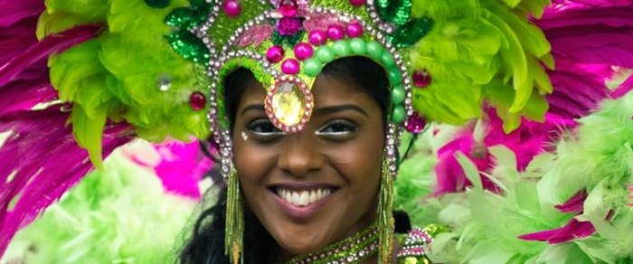 A performer in carnival costume and feathered headdress
