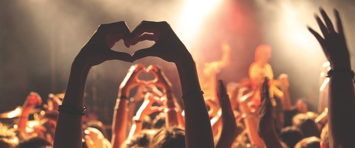 A crowd with raised hands at a live music performance