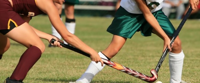 Hockey players contesting the ball on a pitch