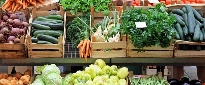 Produce stalls set out at a market in the open air