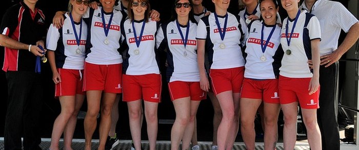 A team in red and white kit holding medals after a competition