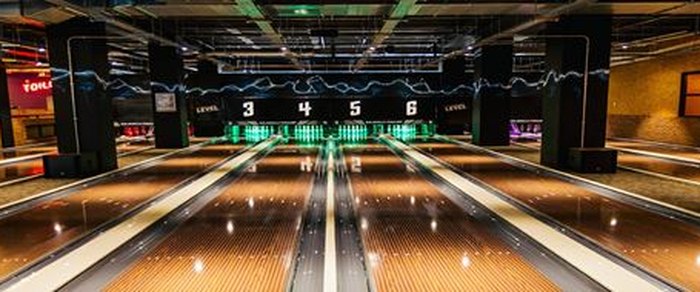 Illuminated ten-pin bowling lanes inside a Preston venue